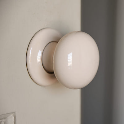 larger detail of cream ceramic door knobs on door