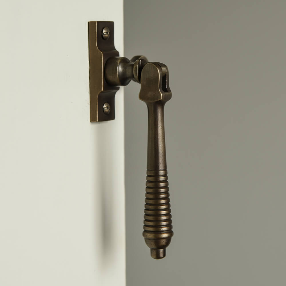 Sash Window fastener in aged antique brass with beehive reeded detailing to the drop pull