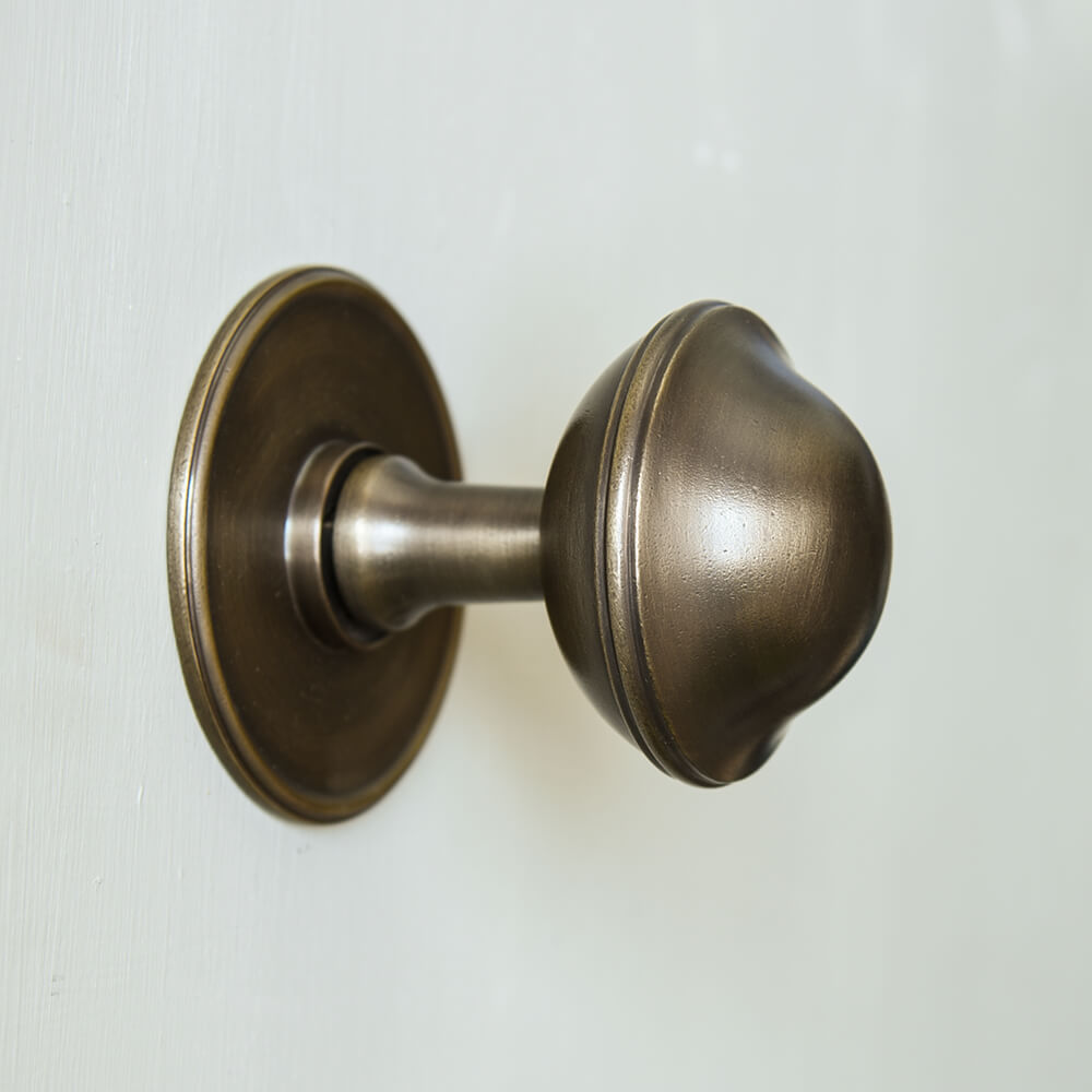 large round brass door pull on cream door