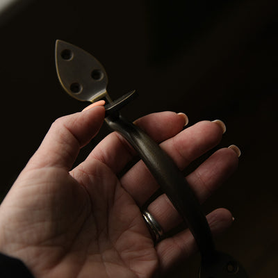 Brass suffolk latch shown in hand for scale
