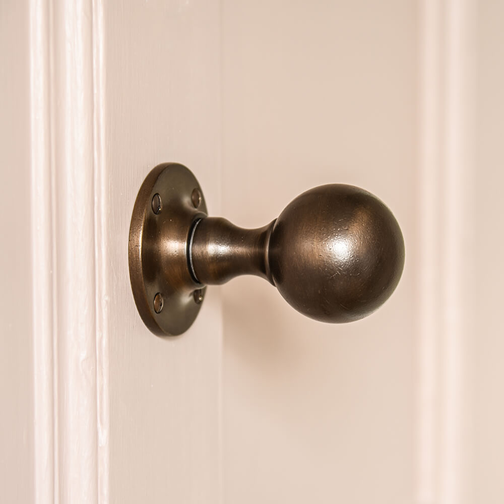 Round Distressed Antique Brass Door Knobs - on pink door