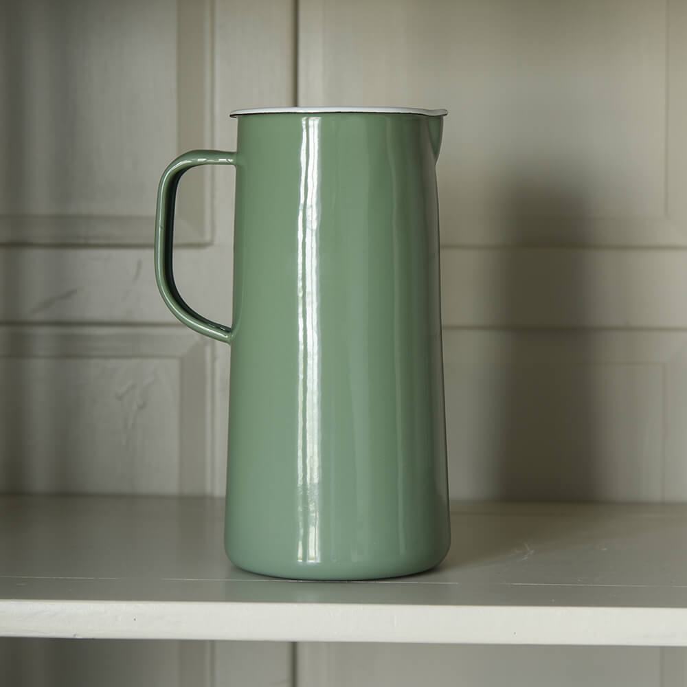 Green enamel jug on a shelf on a dresser