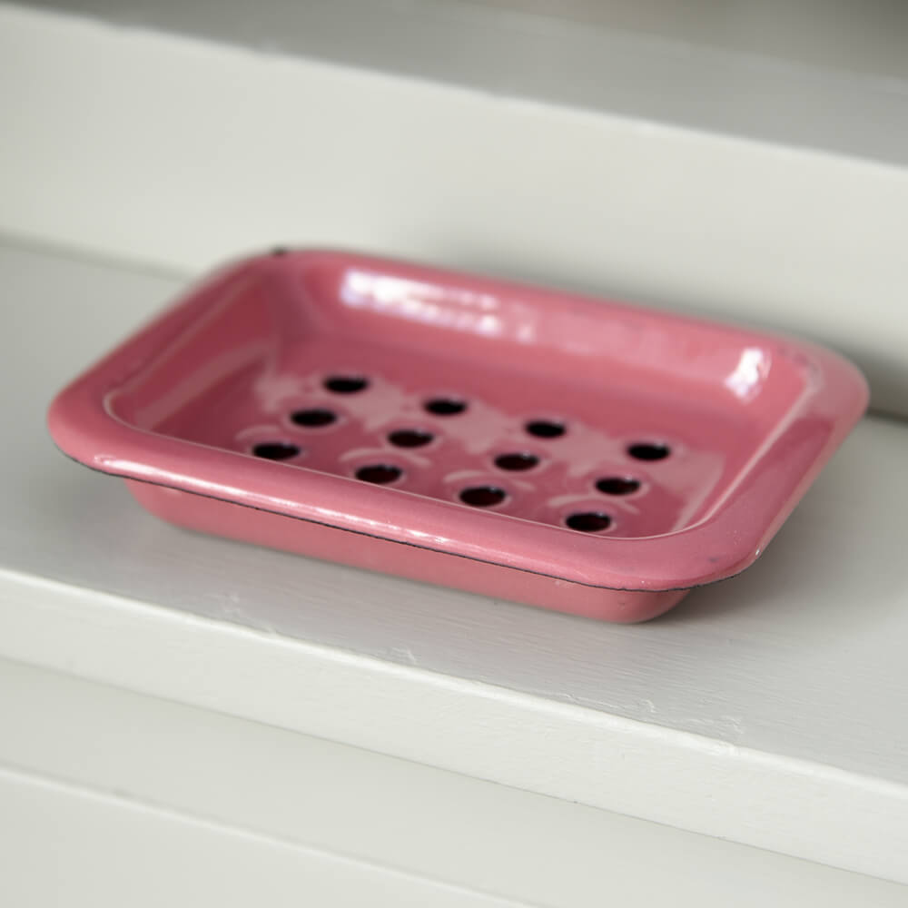 Pink metal soap dish on shelf