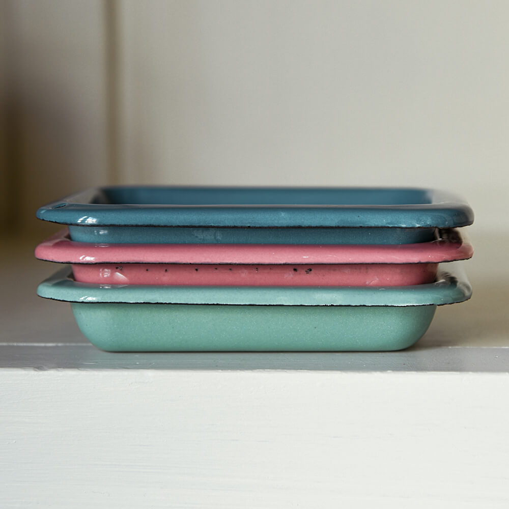Stack of colourful enamel soap dishes on a shelf