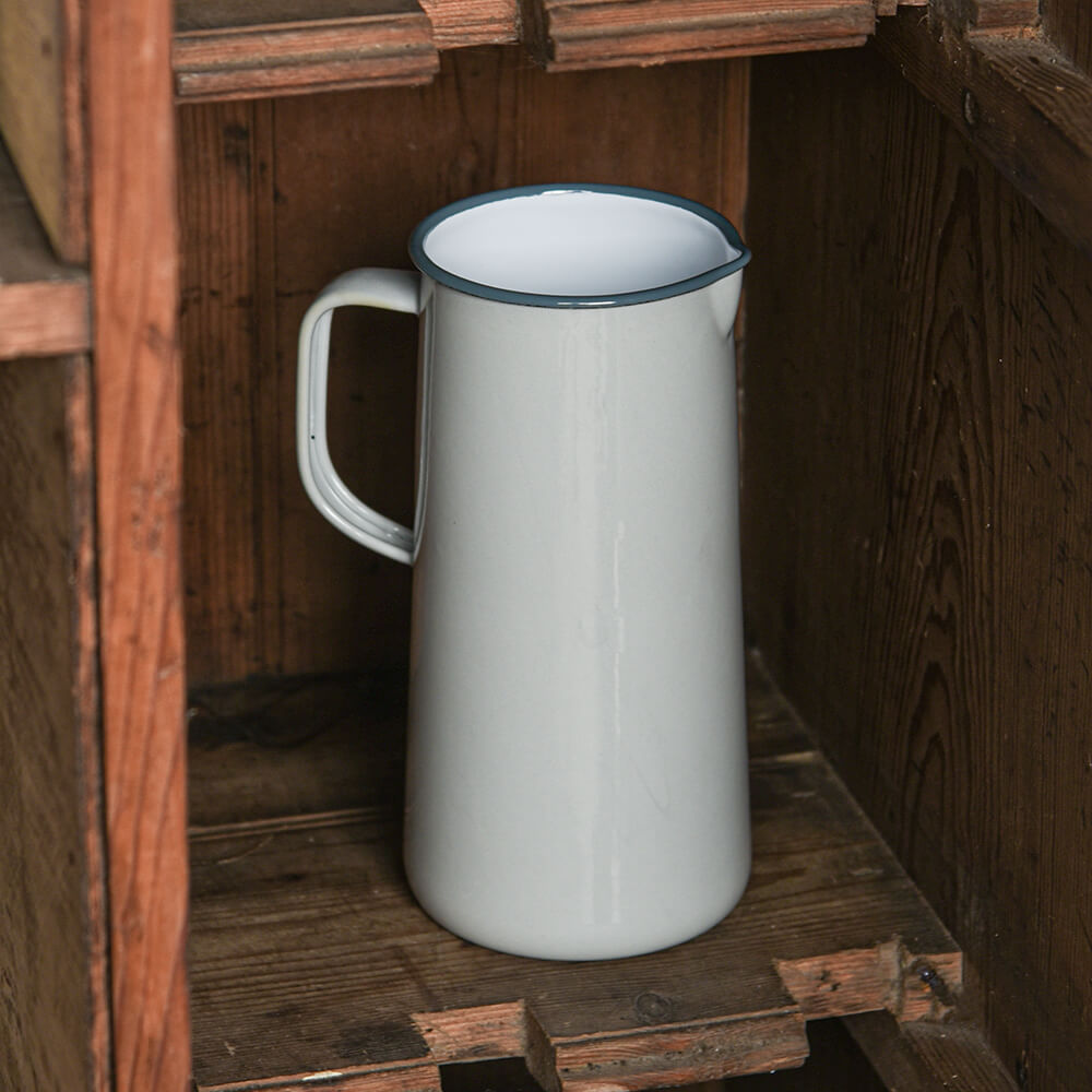 grey enamel pitcher with dark grey rim on a wooden shelf