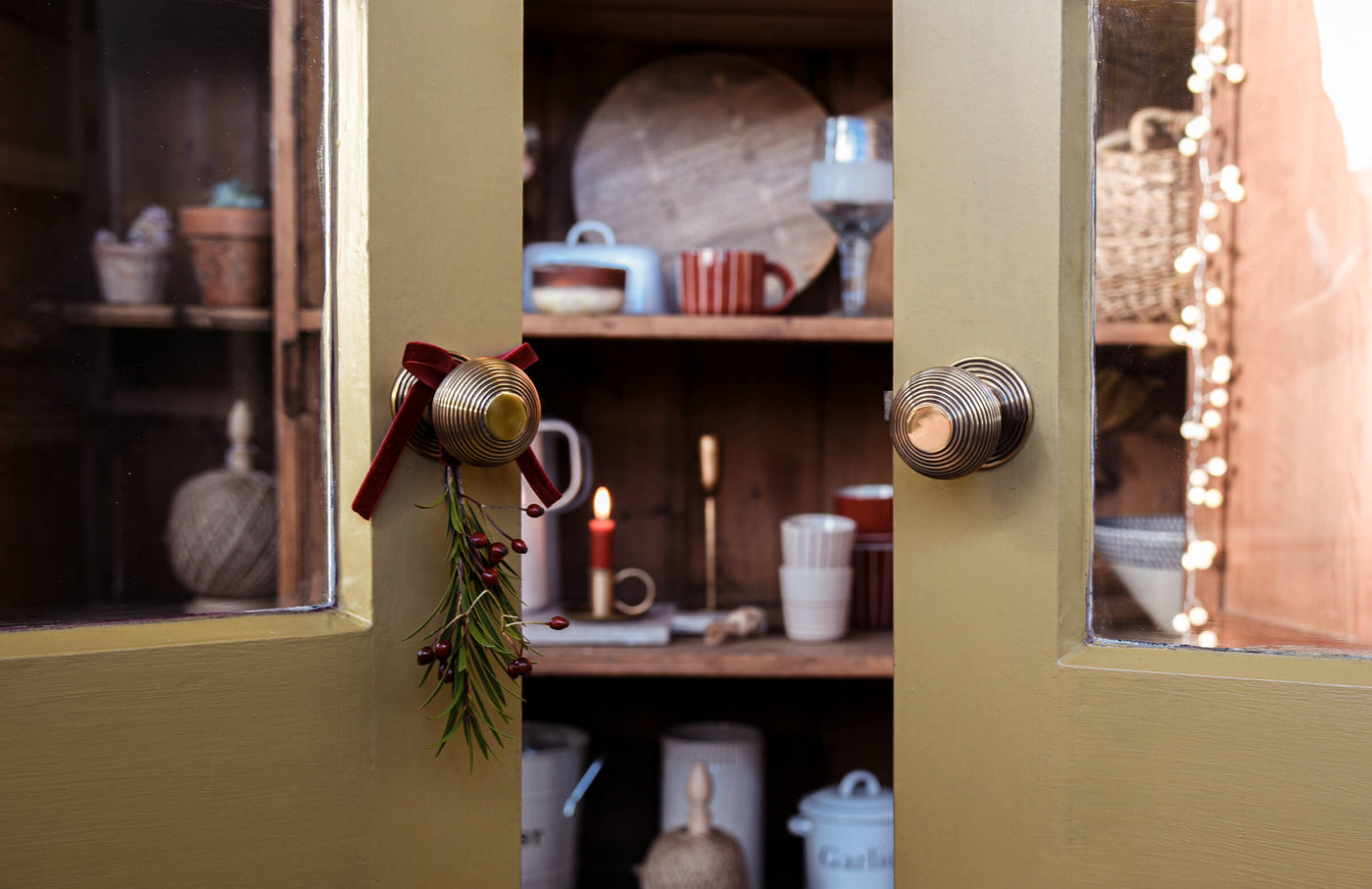 Two doors with brass handles looking into a cupboard
