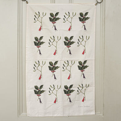 Tea towel on a door with little illustrations of ladies holding holly sprigs