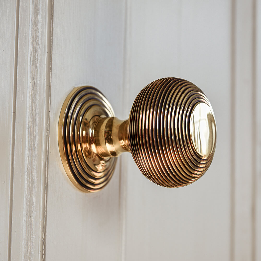 Brass door handle on a white wooden door