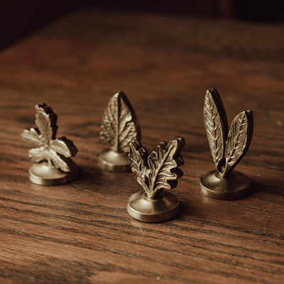 Brass leaf design place card holders on a dining table