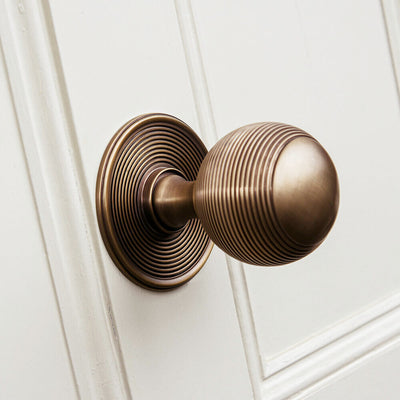 Bronze door handle on a white wooden door