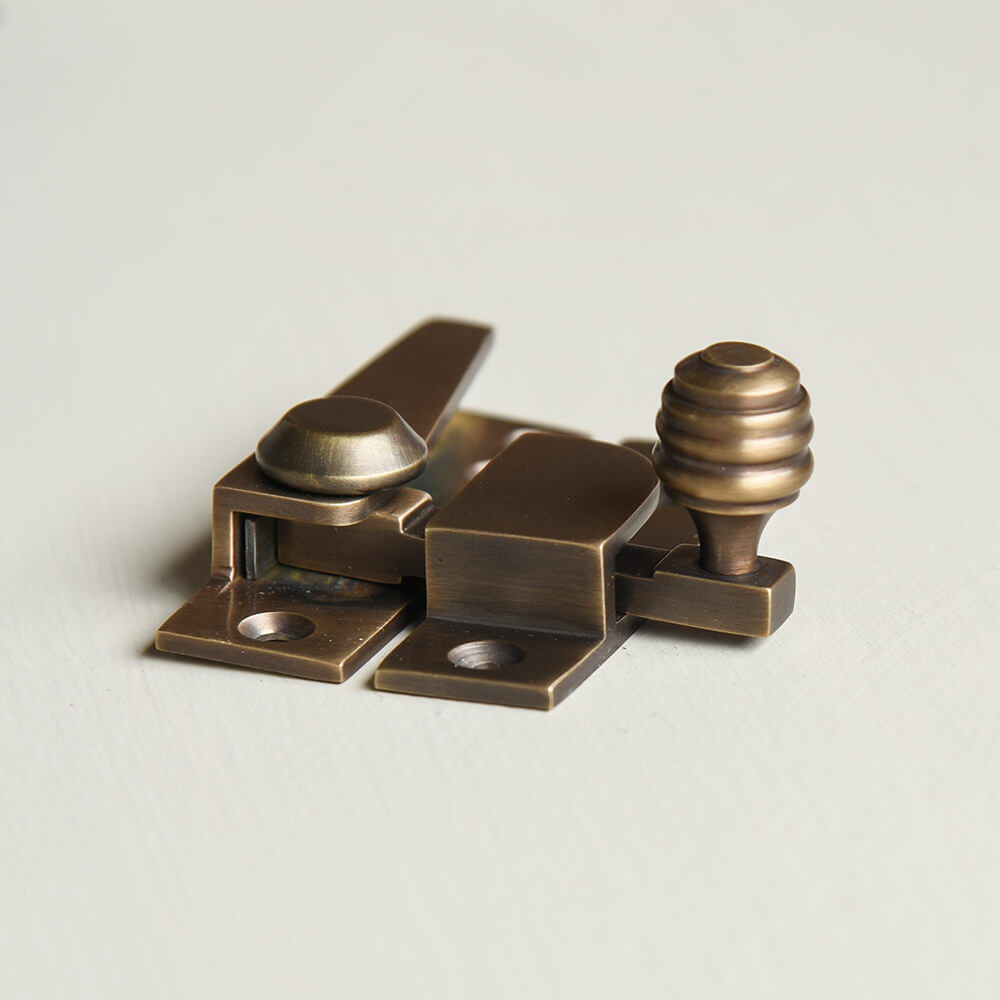 Brass window fastener on a light gray background