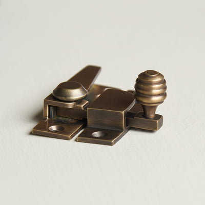 Brass window fastener on a light gray background