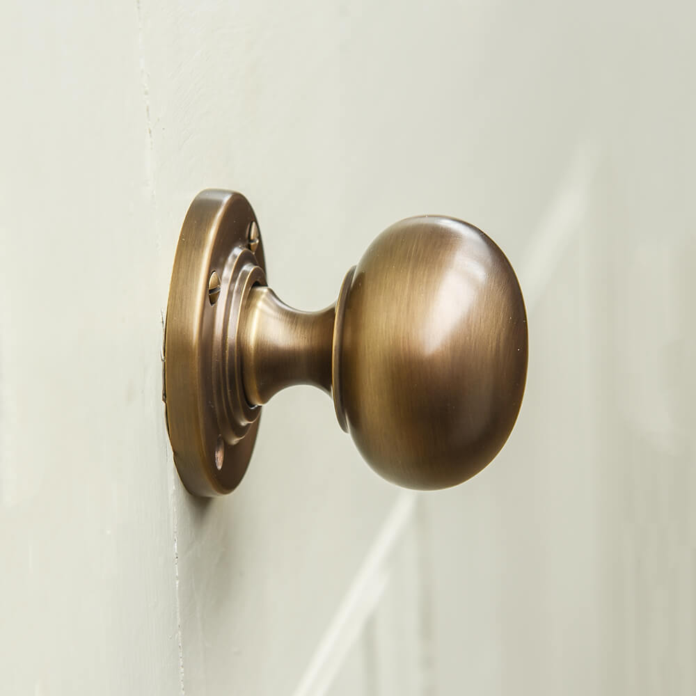 Bun shaped Brass door handle on a white background