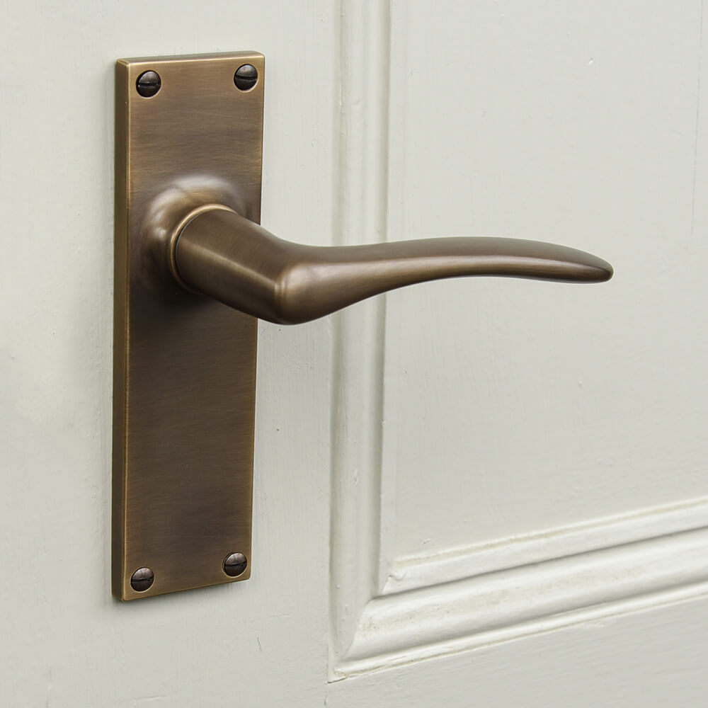 darkened brass door handle on a taupe door