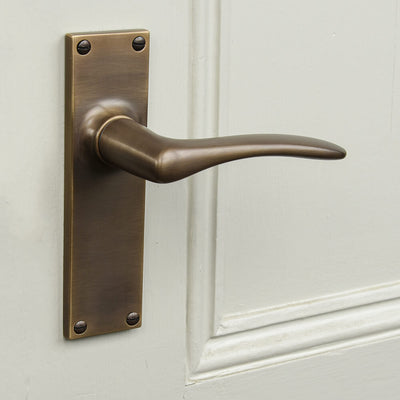 darkened brass door handle on a taupe door