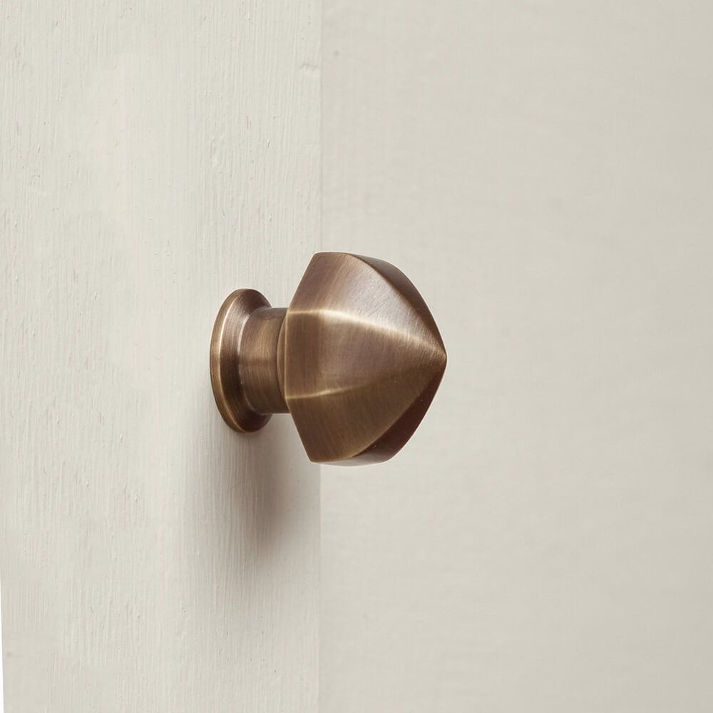 Brass door handle on a light beige wall
