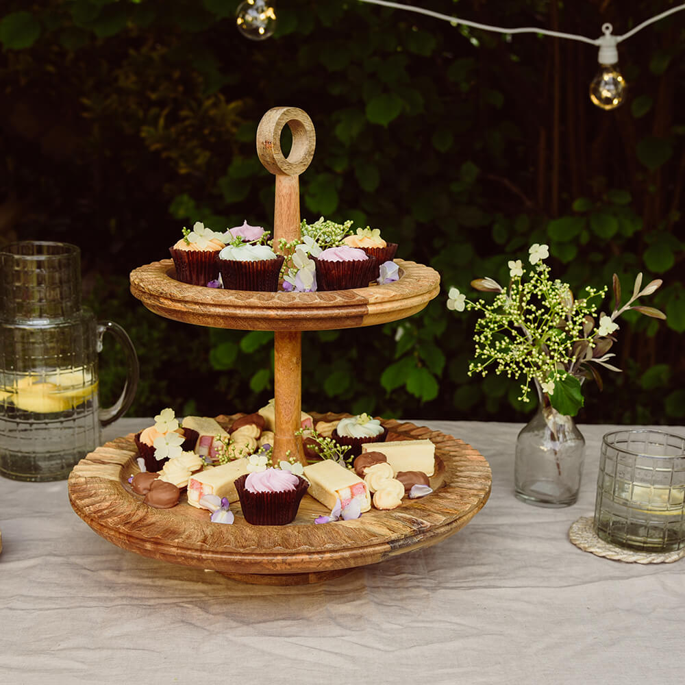 Mango Wood Gavivi Cake Stand outdoors for summer party with cakes and flowers