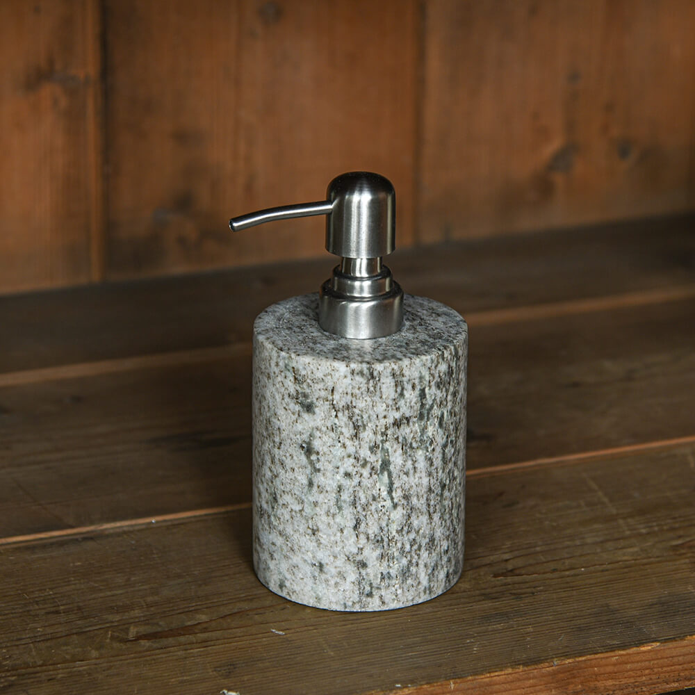 Soap dispenser with granite base and silver pump on a wooden surface