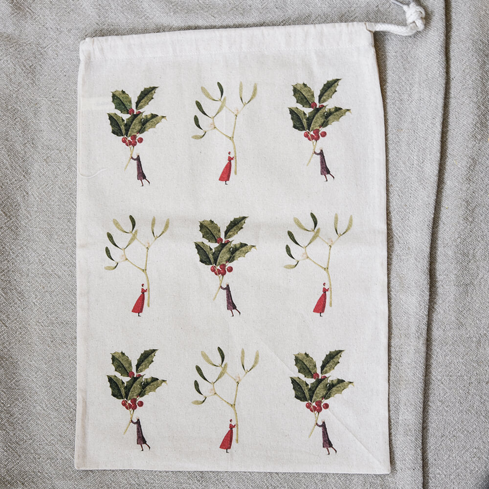 Bag with sprigs and miniature people on a beige background