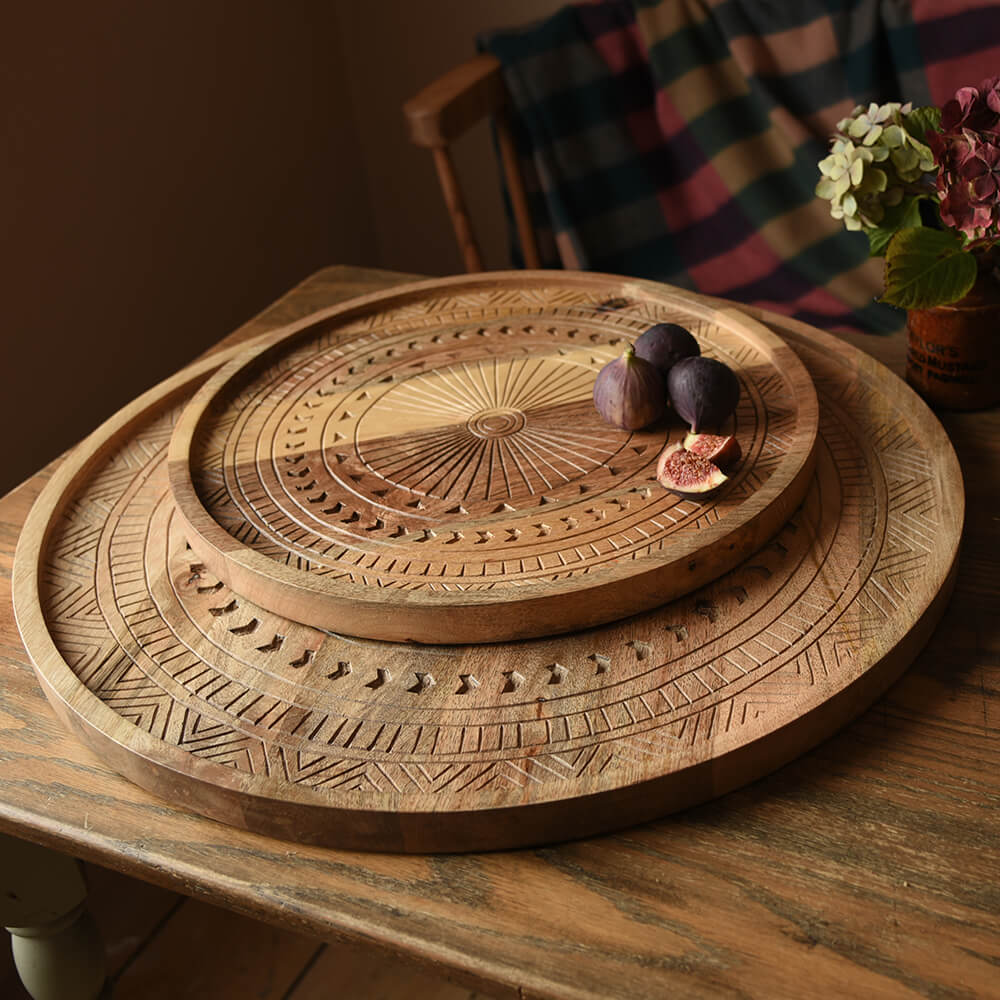 Two round carved wooden trays with figs and flowers