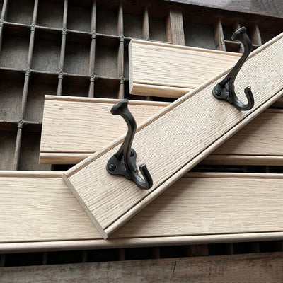 Wooden planks with black metal hooks on a wooden surface