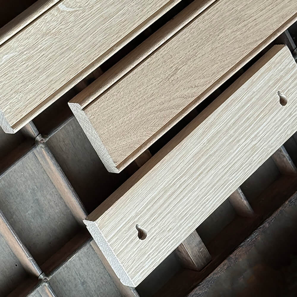 Close-up of wooden backplates with the rear seen with screw holes on a dark background