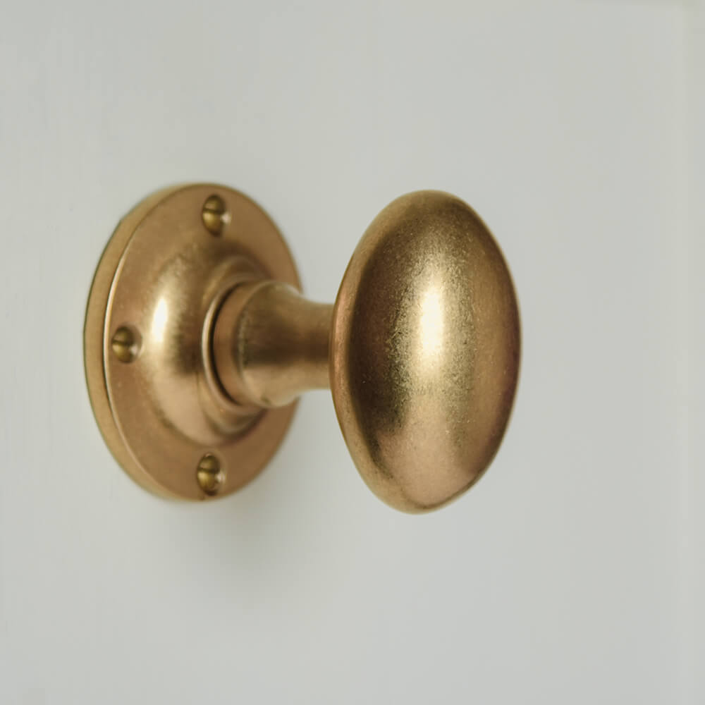 Oval brass door knobs on cream door