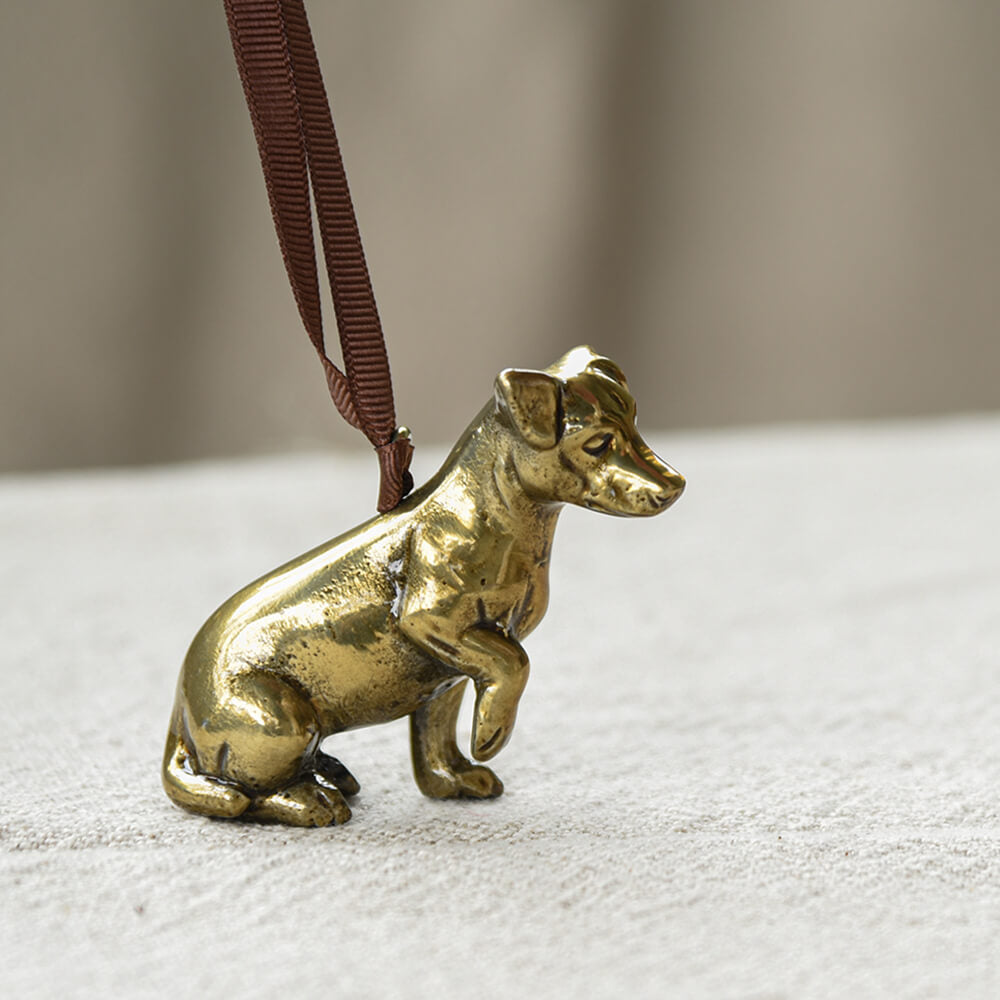 Bronze dog figurine on a white surface with a blurred background