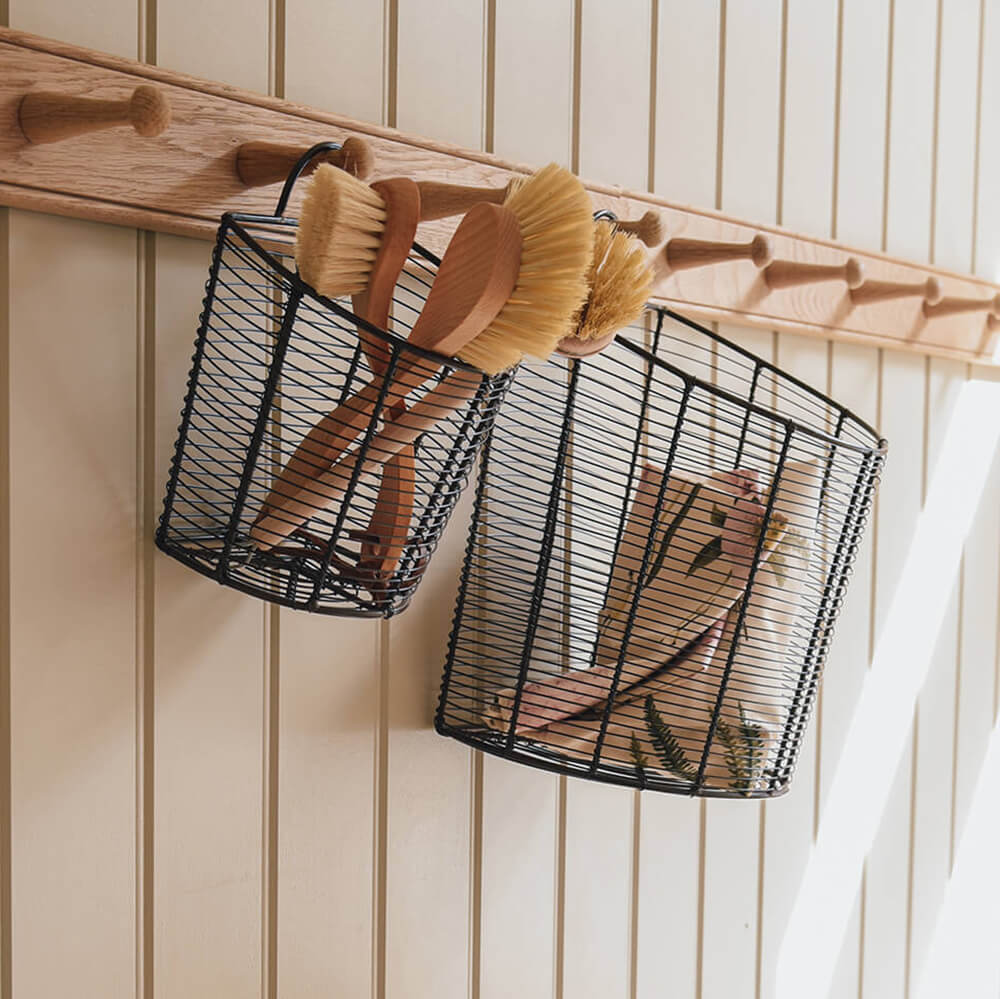Wire basket hung on a peg rail holding products
