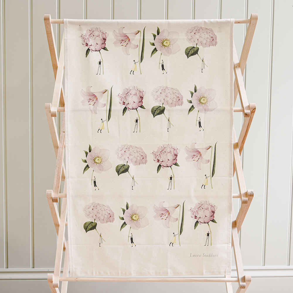 Floral patterned towel on a wooden ladder against a white paneled wall