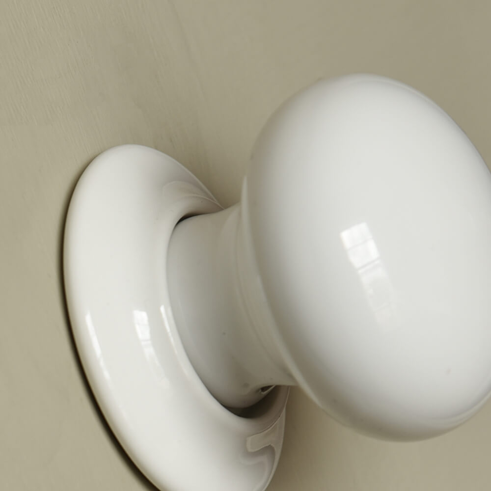 White ceramic door knob on door close up