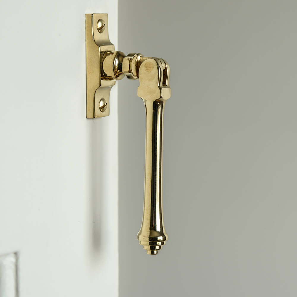 Polished Brass Casement window fastener with long drop pull that has reeded detail to the bottom