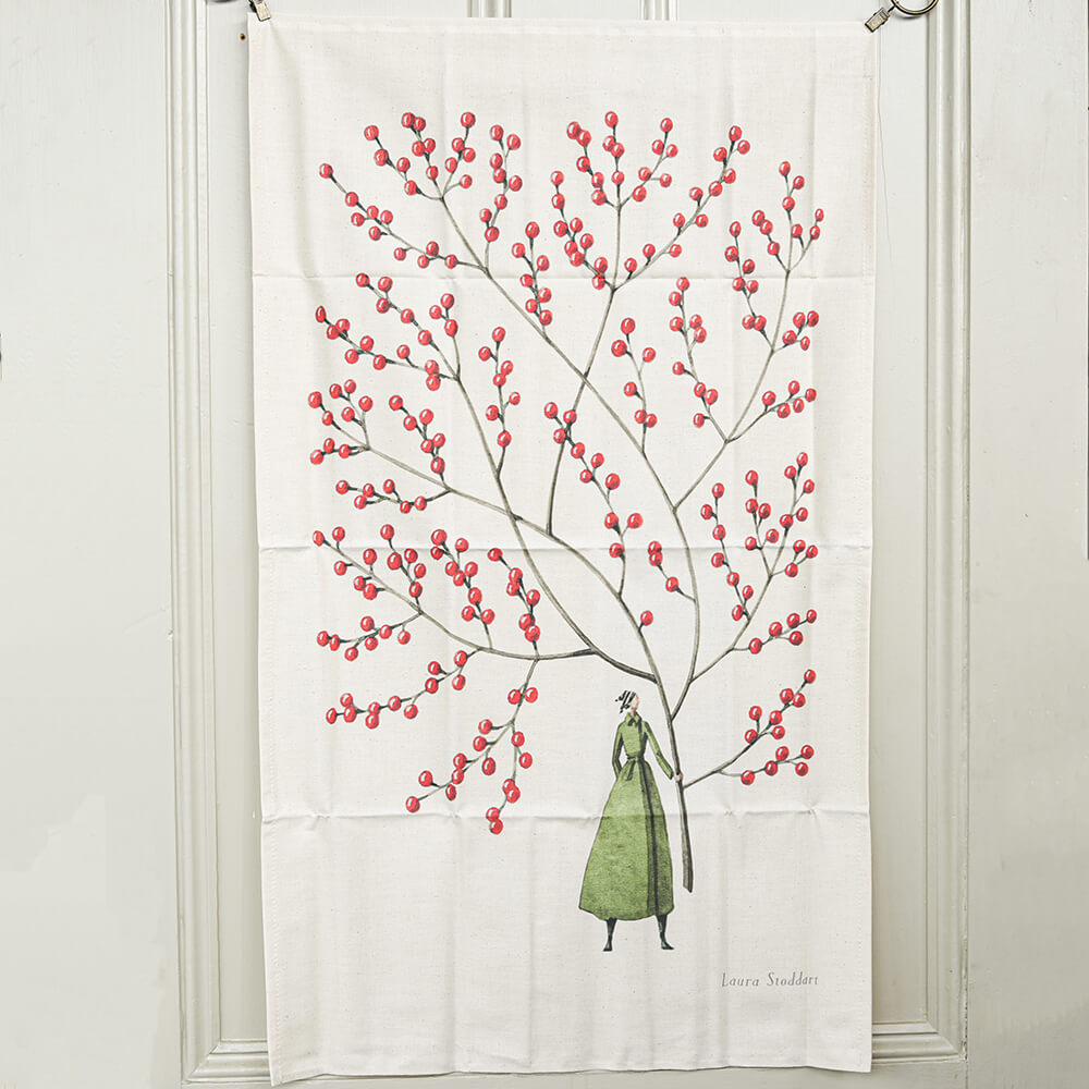tea towel with a design of a woman under a tree with red berries on a white background