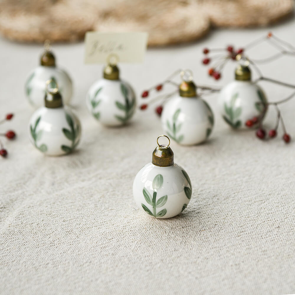 Decorative Christmas ornaments with leaf patterns on a textured surface FOR PLACE CARDS