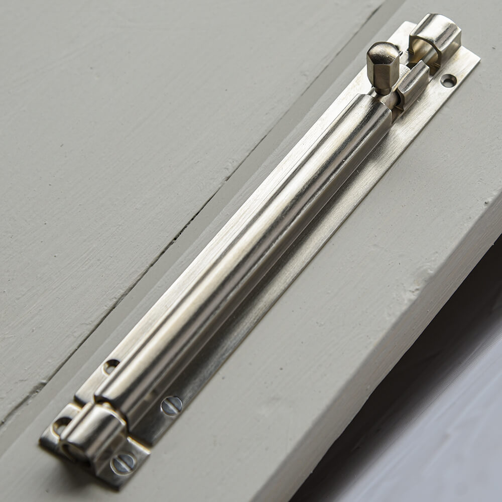 Metal door slide bolt on a grey door