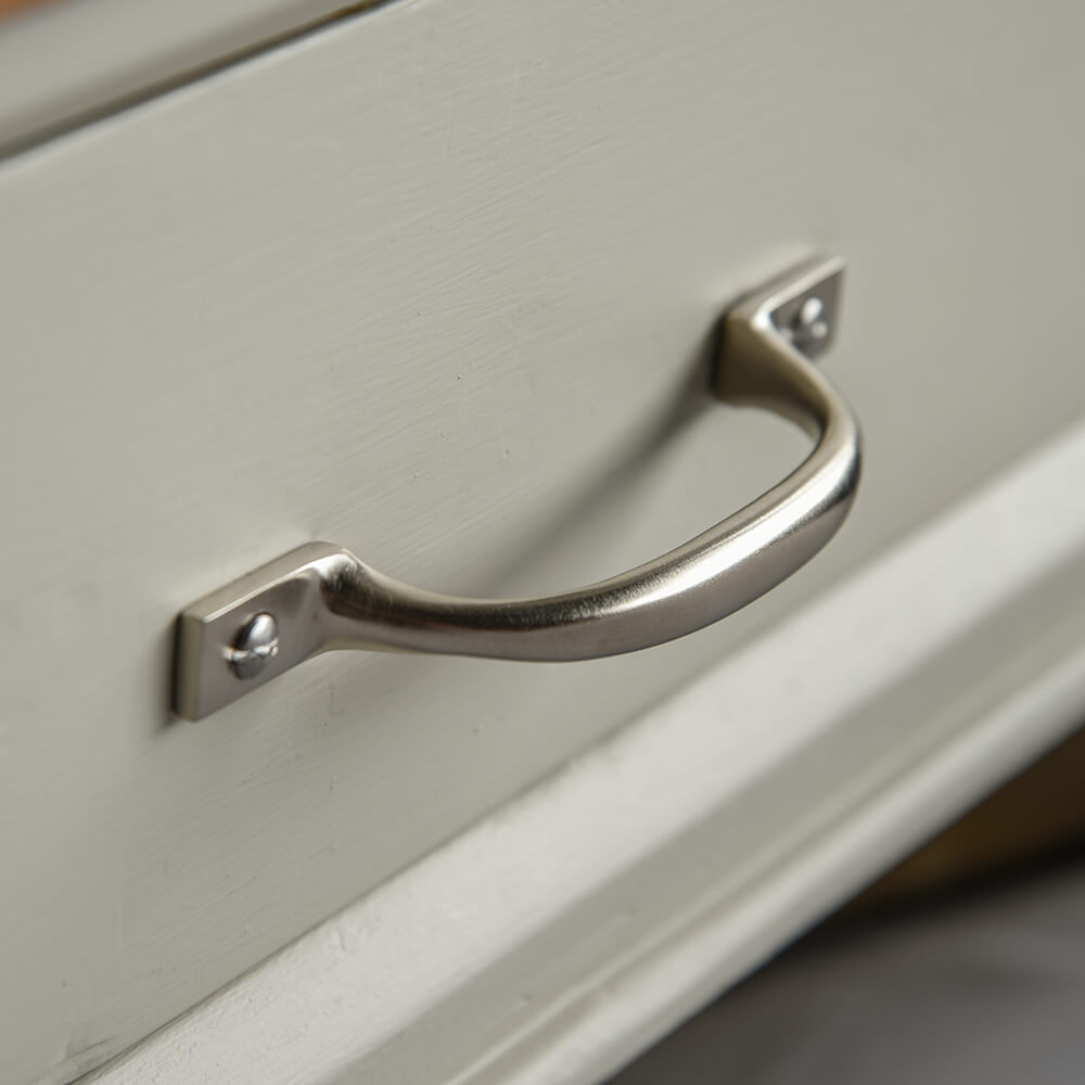 brush silver handle on a light-coloured cabinet door