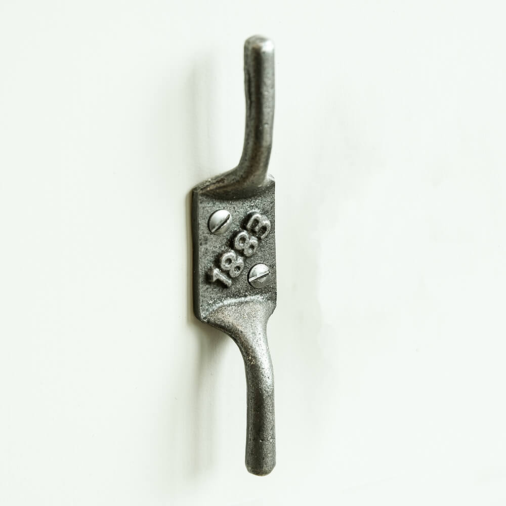 Cast iron cleat hook with '1833' engraving on a white background