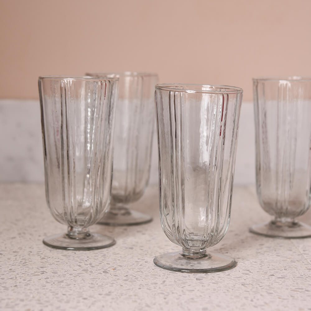 Four decorative drinking glasses on terrazzo against a pink wall