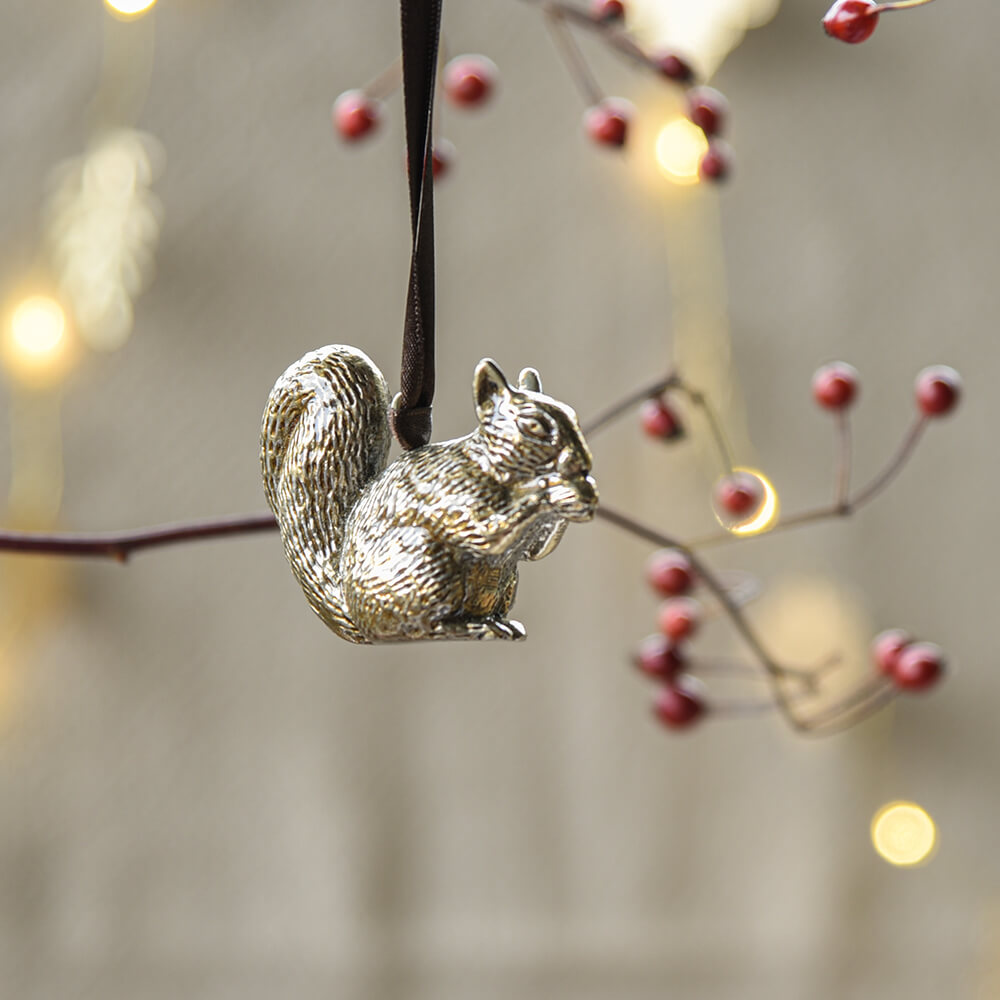 Squirrel shaped brass decoration hanging from a branch