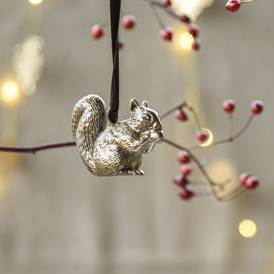 Squirrel shaped brass decoration hanging from a branch