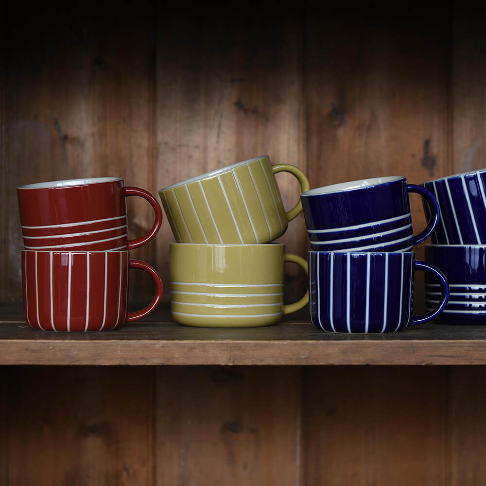 Colourful Striped mugs on wooden shelves