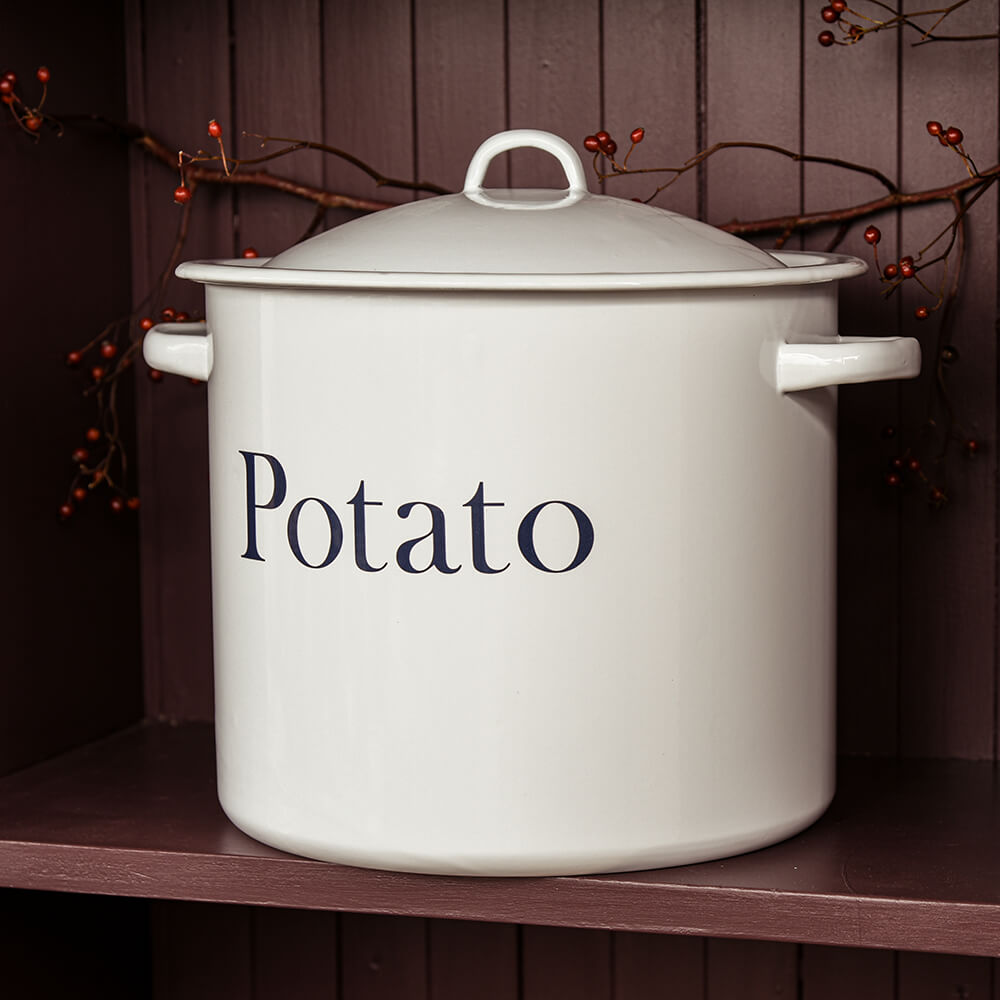 White enamel pot labeled 'Potato' on a wooden shelf with a dark background