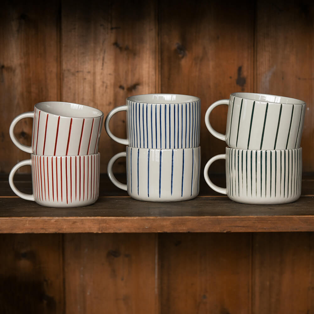 Six striped mugs on a shelf