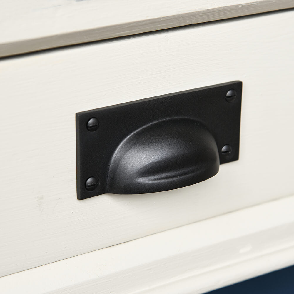 Black pull handle on a cream drawer