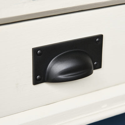 Black pull handle on a cream drawer