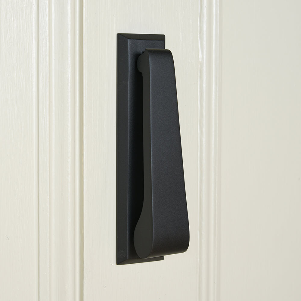 Black door handle on a white paneled door