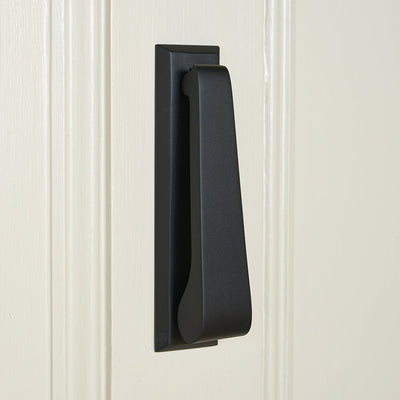 Black door handle on a white paneled door