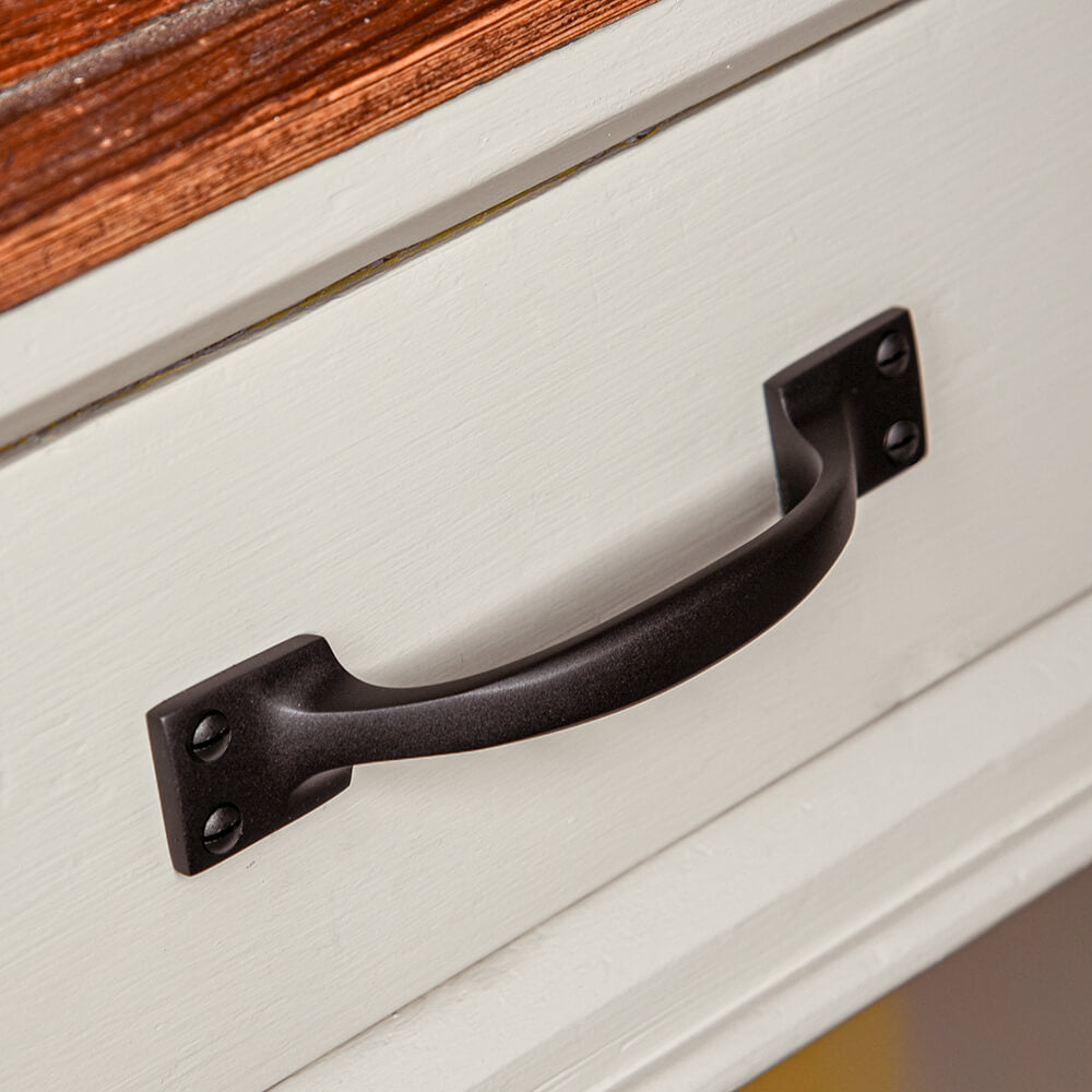 Back curved handle on a pale drawer front