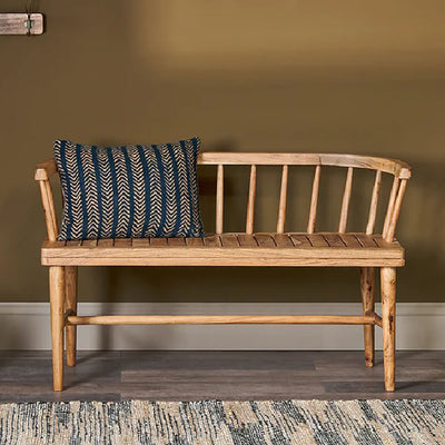 Acacia wood bench with backrest against olive green wall with blue and cream striped cushion placed on top