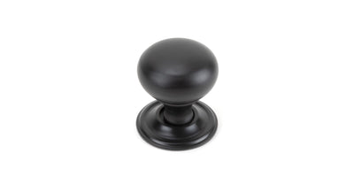 Solid aged bronze cabinet knob against a white background